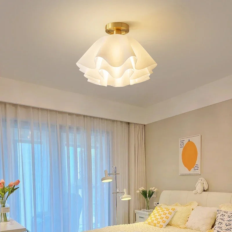 Nowoczesna lampa sufitowa z falistym kloszem z tkaniny i mosiężną bazą