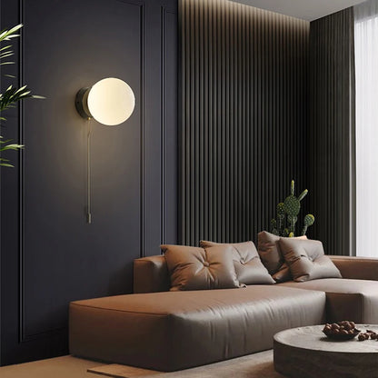 Kinkiet ścienny z kulistym kloszem i łańcuszkiem – nowoczesna elegancja w minimalistycznej formie