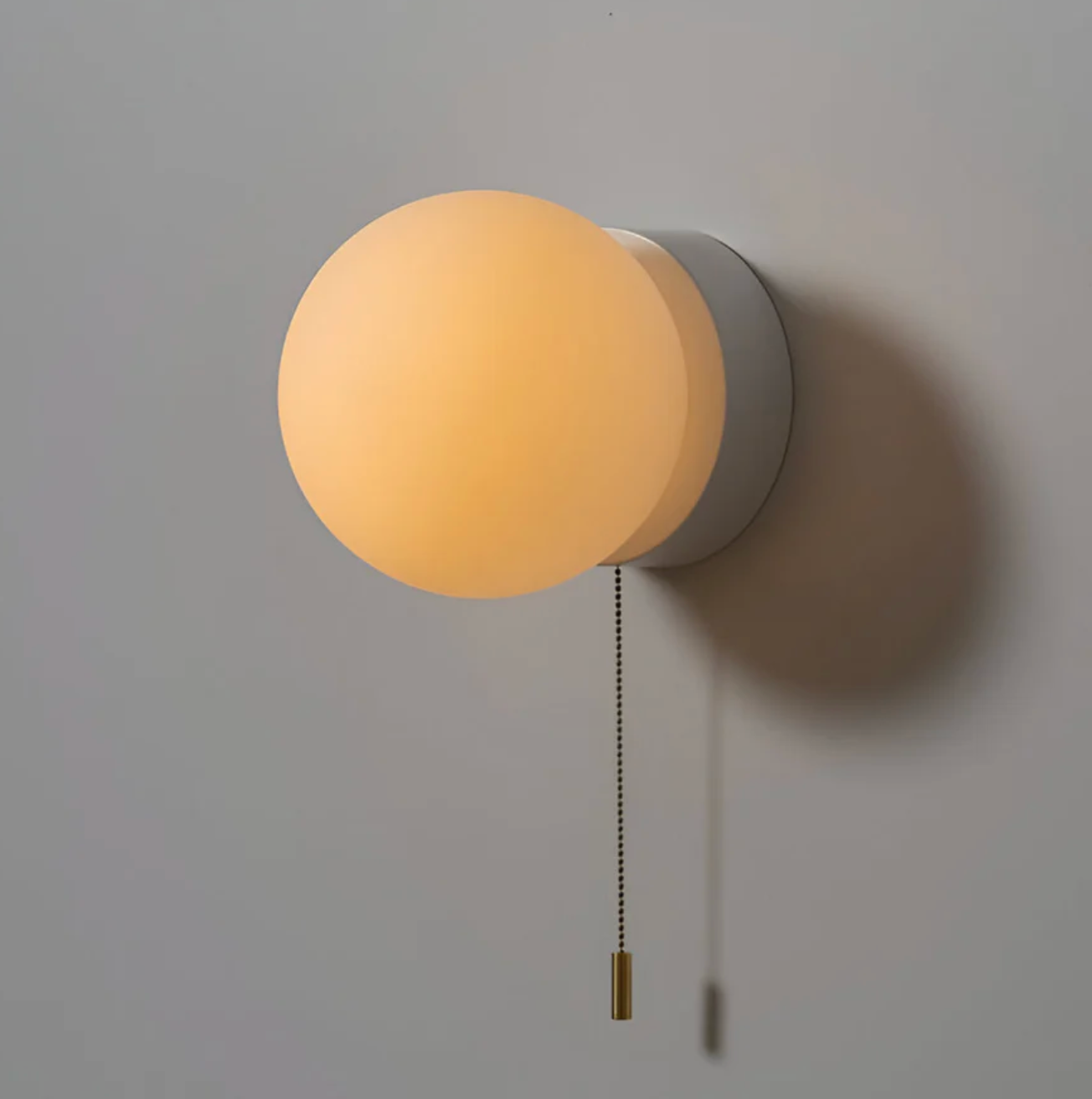 Kinkiet ścienny z kulistym kloszem i łańcuszkiem – nowoczesna elegancja w minimalistycznej formie