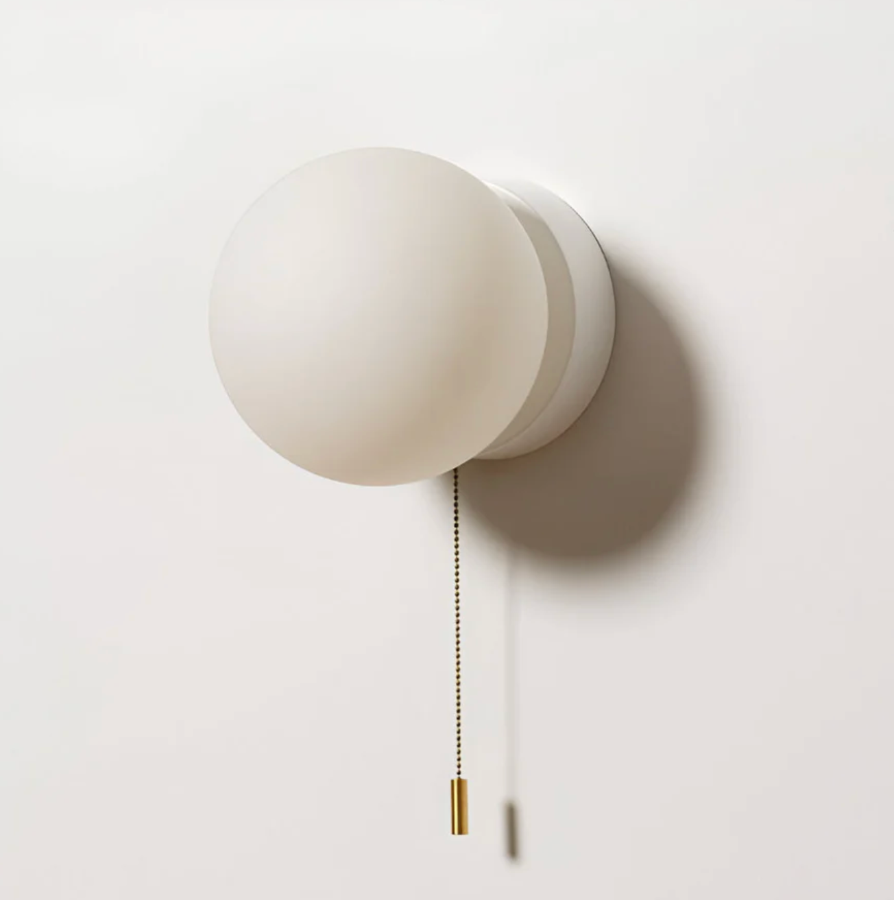 Kinkiet ścienny z kulistym kloszem i łańcuszkiem – nowoczesna elegancja w minimalistycznej formie